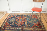 Geometric design and distressed pile of the antique Seichor Kuba rug, with indigo, cherry red, and animal motifs.