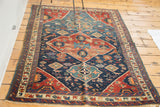 Distressed dark blue field of antique Seichor Kuba rug with detailed animal figures.