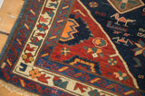 Distressed corner of antique Seichor Kuba rug showing tribal geometric patterns, stylized animals, and fringe.