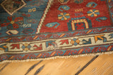 Fringe and distressed geometric border of the Antique Seichor Kuba rug with visible repair.