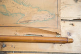Aged bottom edge of vintage pull-down map with wooden dowel and engraver's name.