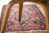Distressed Lilihan rug: blush rose field with intricate serrated leaves and tattered fringe.