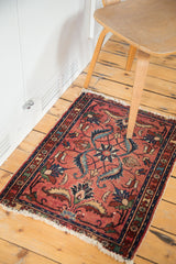 Distressed fringe and border on a vintage Lilihan rug, revealing blush rose field and ornate vines.