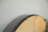 Antique tri folding mirror's rounded top edge, showcasing dark wood patina and age.