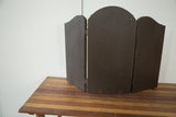 Rear view of antique tri folding mirror, showing dark wooden panels, visible hinges, and rich patina.
