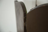 Antique tri folding mirror's dark wood backing with visible hinge detail and patina.