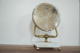 Mid Century Hollywood mirror with spotted round glass, brass frame, and marble base.