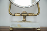 Mid Century Hollywood mirror: spotted glass edge, aged brass and white marble base.