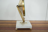 Side view of Mid Century mirror base with white marble and ornate brass elements.