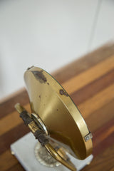 Vintage brass Hollywood mirror frame with discolored spotting.