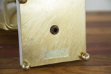 Brass base of the vintage Hollywood mirror with spherical feet and manufacturer label.
