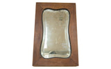 Antique Art Deco bell-shaped mirror, warm brown wooden frame, aged beveled glass surface.