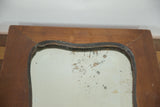 Art Deco mirror's top wood frame with patina and aged, mottled glass.