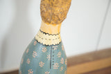 Folk Art Painting Bowling Pin with painted yellow scalloped collar and blue dress with pink flowers.