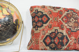 Geometric red, black, and tan patterns on an antique Amu Darya rug fragment pillow.