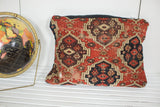 Intricate Amu Darya rug fragment pillow detail: red, aubergine, beige geometric pattern with natural wear.