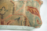 Antique Turkish rug fragment pillow with muted blue, red geometric patterns and velvet trim.