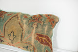 Close-up of late 18th century Turkish rug fragment's hand-knotted weave, teal, rust, and beige.