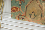 Hand-knotted weave detail on the antique Turkish fragment pillow in teal, pink, and terracotta.