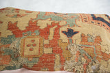 Worn texture and exposed threads on an antique yellow Serapi rug fragment pillow.