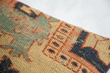 Antique Serapi pillow detail: age-worn geometric motifs in blue, red, and yellow.