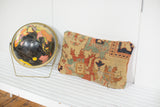 Antique Serapi rug fragment pillow featuring aged yellow ground and worn traditional patterns.