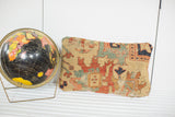 Antique Serapi pillow displaying aged yellow, red, and teal geometric patterns with wear.