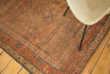 Distressed pile of the antique Kurdish rug, highlighting muted geometric patterns and faded borders.