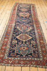 Detailed geometric pattern, worn red border, and indigo field of an antique Karaja runner.