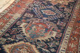 Antique Karaja rug's distressed indigo field, featuring geometric animal and human motifs.