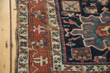 Distressed madder red geometric border and indigo field of an antique Karaja rug.