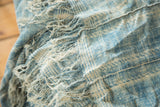 Vintage African textile's hand-woven texture, intricate indigo blue and ivory panel seams.