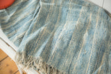 Vintage African indigo textile, handwoven with powder blue stripes, textured cotton, and fringe.