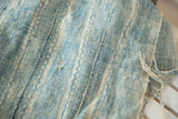 Textured close-up of hand-woven vintage African textile in powder blue with natural character.