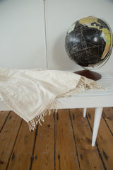 Natural ivory hand-woven cotton African textile with short tassels and fine texture.