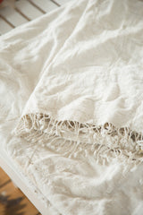 Collectible ivory African textile throw showing finely hand woven texture and tassels.