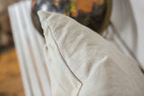 Textured linen fabric on the corner of a sun-faded powder blue indigo pillow.