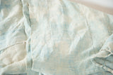Close-up of intricate hand-woven texture on a vintage ivory and powder blue African textile.