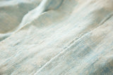 Handwoven ivory and powder blue African textile with vintage texture and subtle color shifts.
