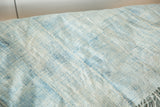 Textured vintage African textile detail, soft powder blue with visible hand-weaving and subtle stitches.