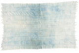 Hand-woven vintage African indigo textile throw in powder and denim blue with fringed edges.