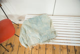 Vintage African indigo textile with fringed edge and soft blue, denim blue hues.