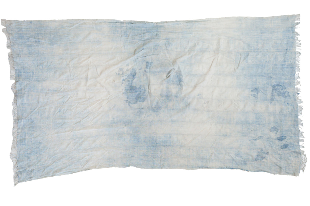 Vintage African hand-woven textile throw in faded indigo and ivory, with tassels.
