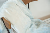 Detail of hand woven African indigo textile's soft ivory and powder blue cotton folds.