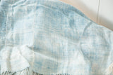 Soft, hand-woven vintage African indigo textile displaying varied powder blue tones and tassels.
