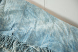 Textured hand-woven vintage African indigo throw in powder blue, showing stitched lines and fringe.