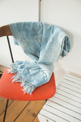 Detail of hand-woven vintage African textile, showing short tassels and soft blue tones.
