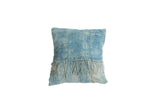 Vintage light blue indigo pillow with sun-faded textile and frayed tassels.