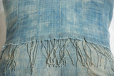 Vintage light blue indigo pillow showing sun-faded textile and delicate fringe.