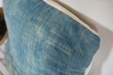 Sun-faded light blue indigo textile of vintage pillow, showing handwoven texture.